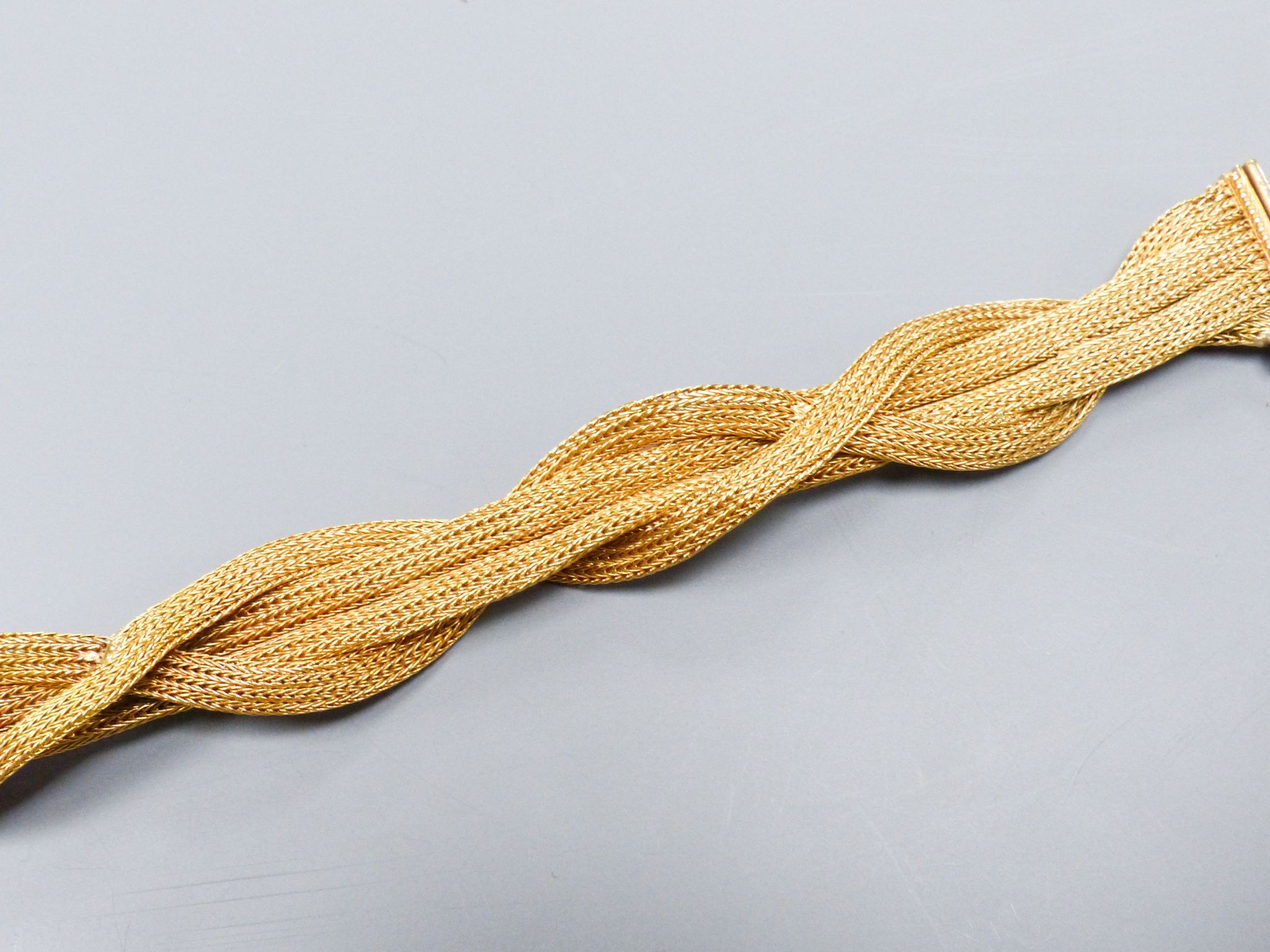 An 18ct gold plaited mesh bracelet, 19cm, 31 grams (repair).